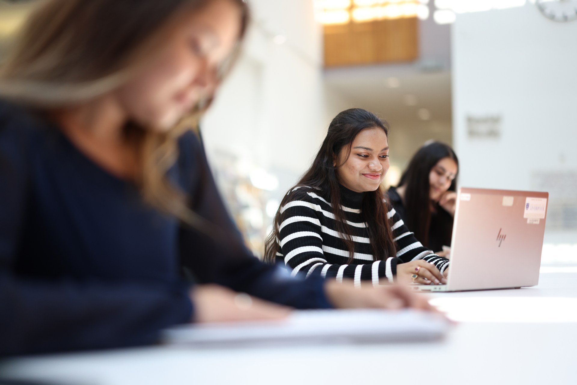 A student using a laptop in a campus study space.