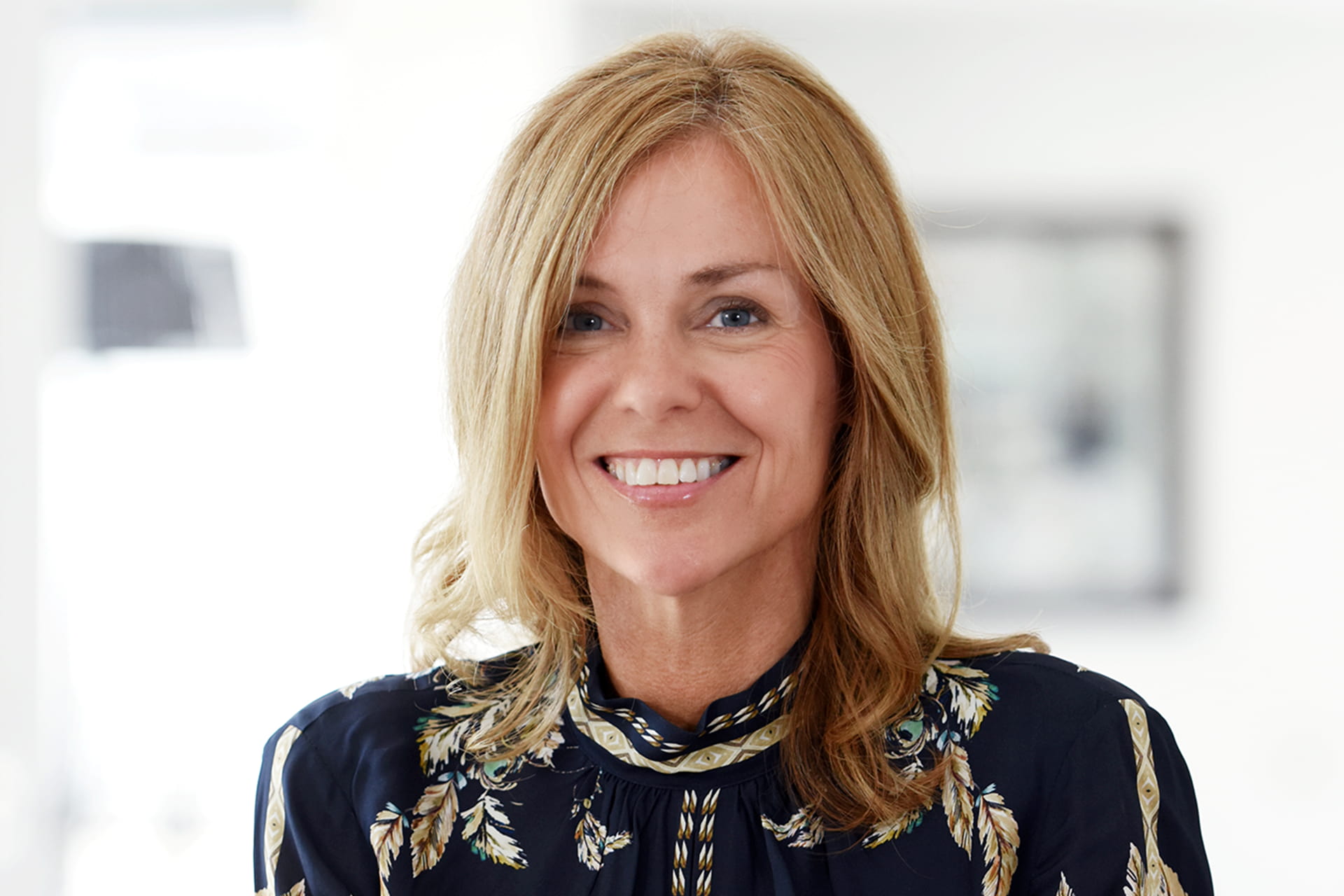 A photo of Adele Parks smiling. She is a woman with blue eyes and shoulder-length blond hair.