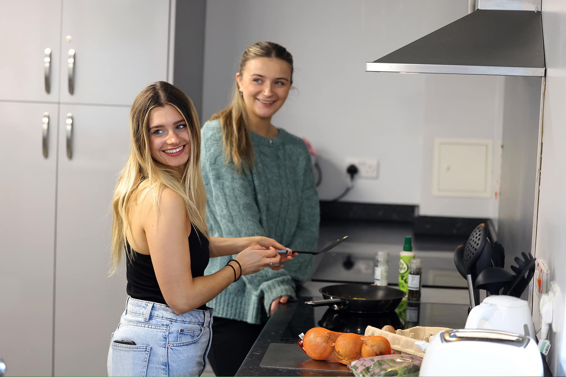 Two students cooking in the kitchen of University halls