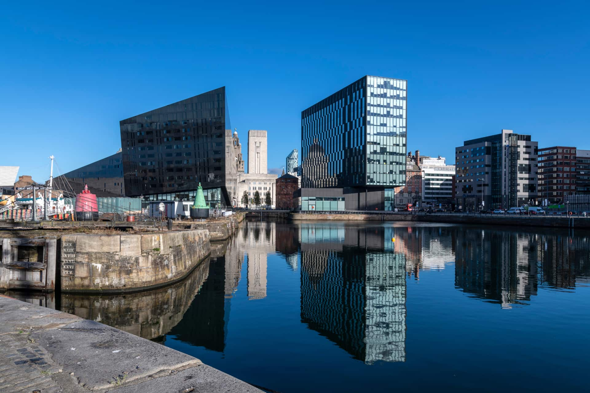 A section of the Liverpool waterfront with a canal cutting between two tall, black, modern buildings.