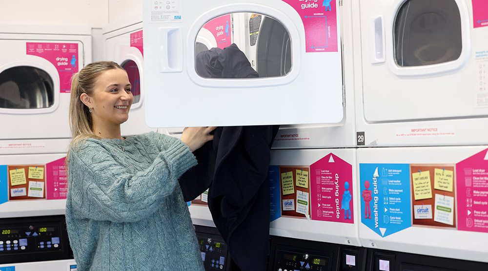 Lily doing her laundry in her accommodation