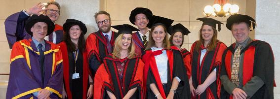 A group of scholars wearing graduation regalia