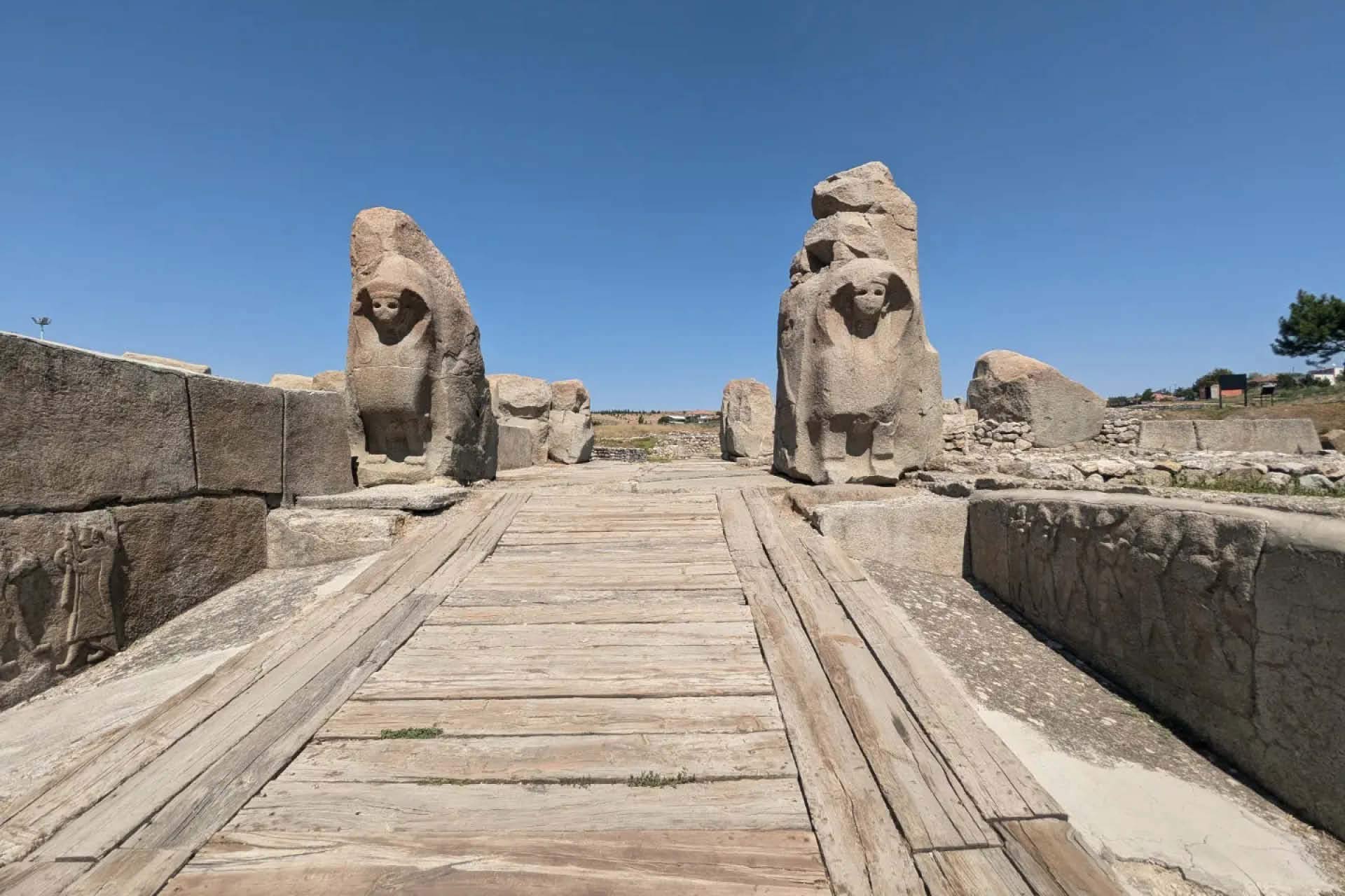 Figures made out of stone at the entrance of an old excavation site outside