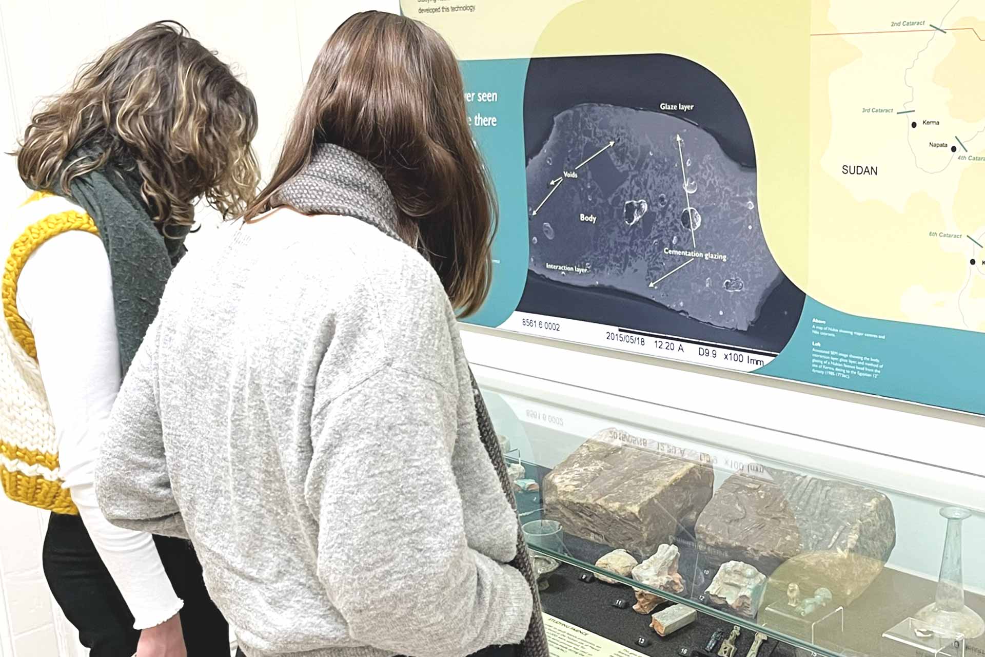 Two students looking at artefacts behind glass in the Garstang Museum