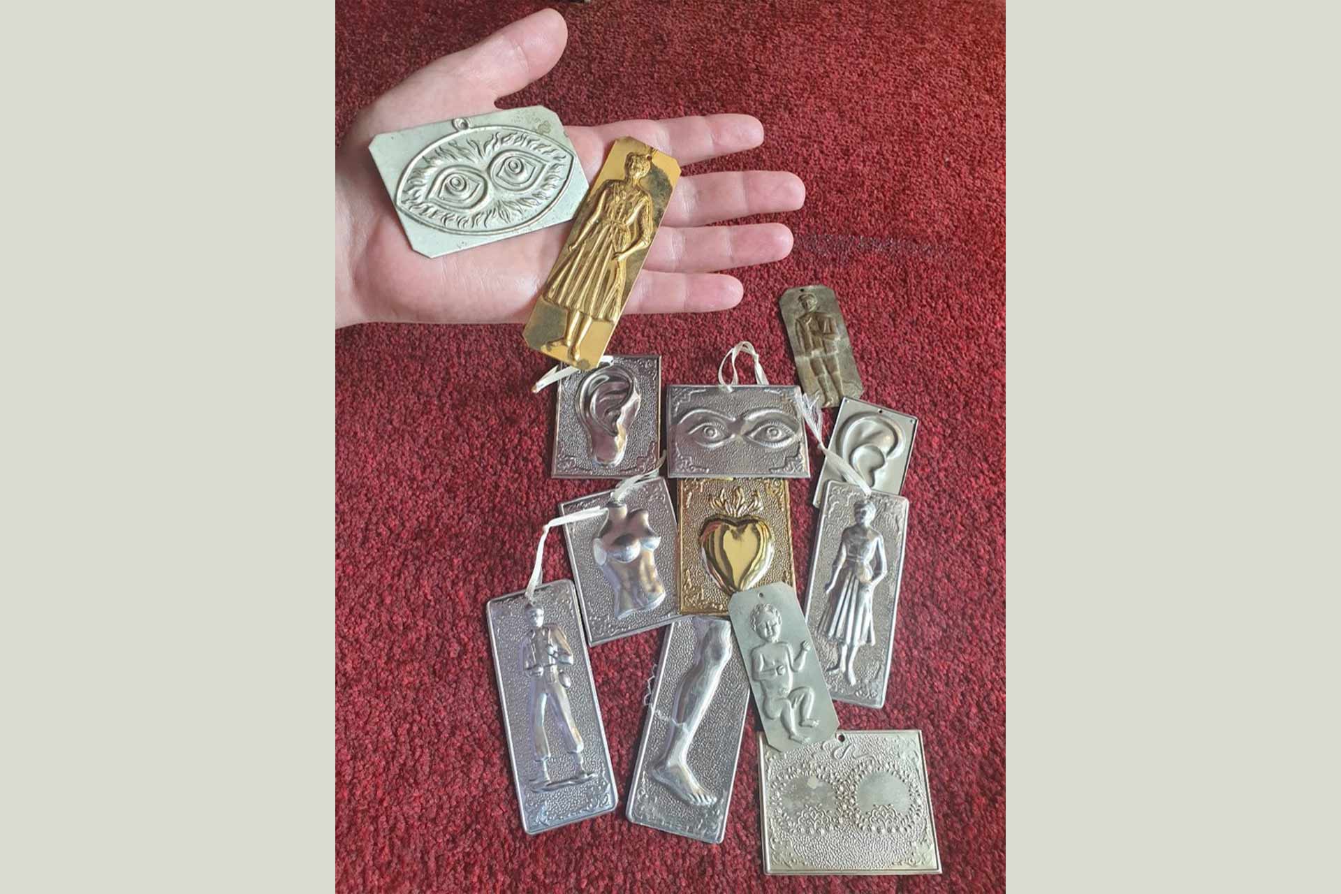 Metallic rectangular shaped objects with images on them such as human body parts and figures.