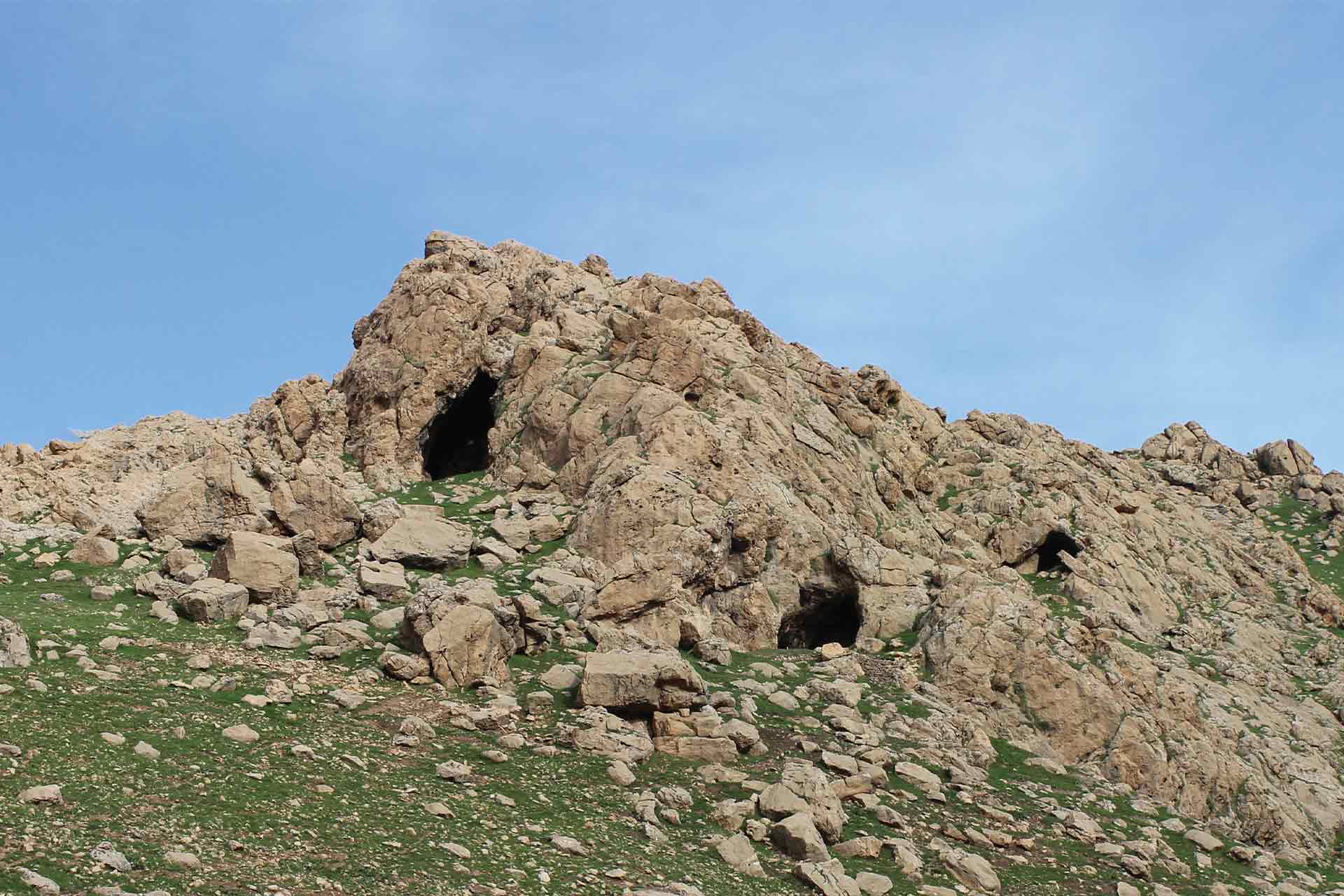The top of a hill or rock mountain with caves in between the terrain,
