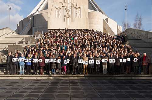 A large group of people standing on the steps outside a cathedral.