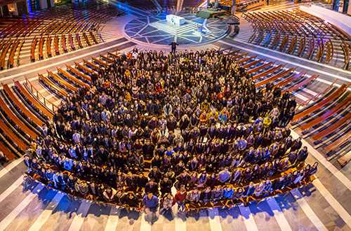 Inside a cathedral, a group of people looking up at the camera.