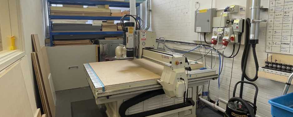 CNC router in a room surrounded by safety equipment.