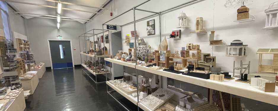 Corridor with racks of architectural models on display.