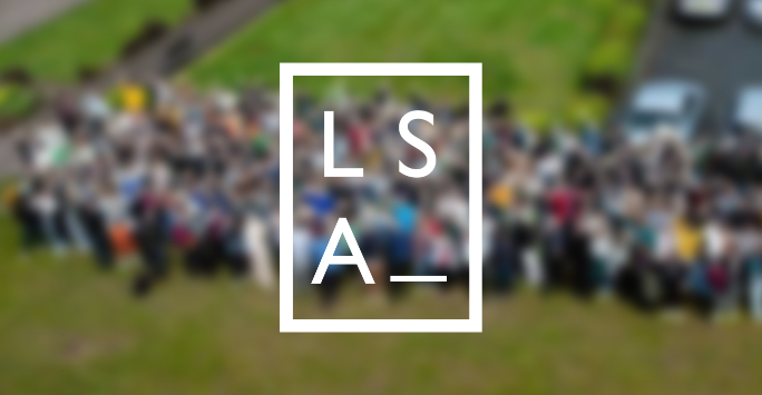 Blurred aerial image of students standing on a glass field with the letters L,S,A superimposed on top.