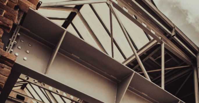 Steel roof beams seen through a demolished wall.