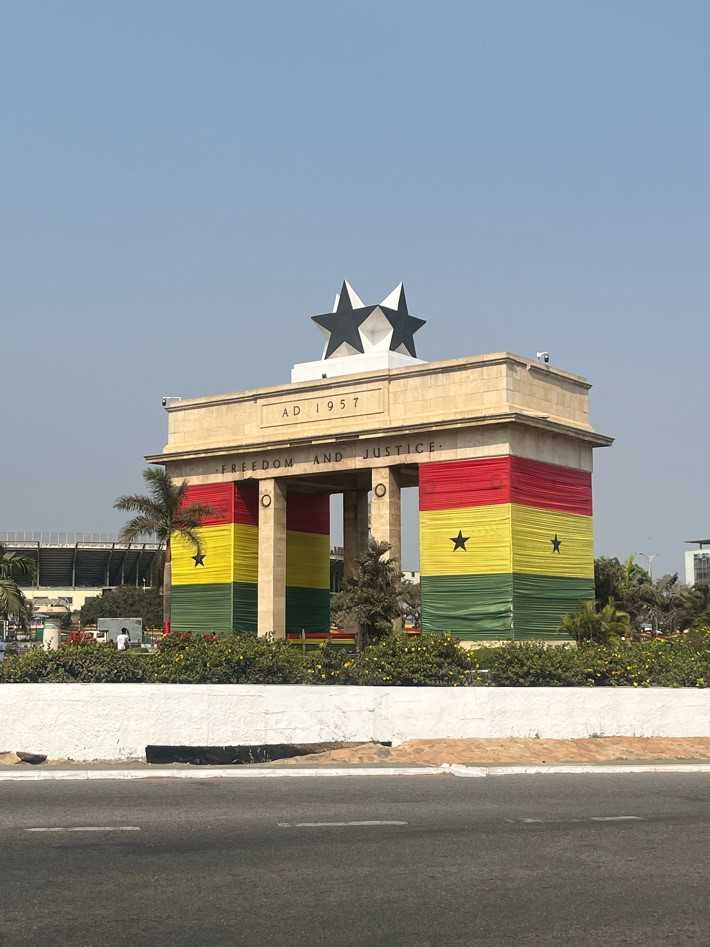 Lareg moument by a road wrapped in the Ghanan flag. 