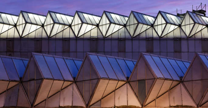 Illuminated glass roof on a glass and brick modernist building.