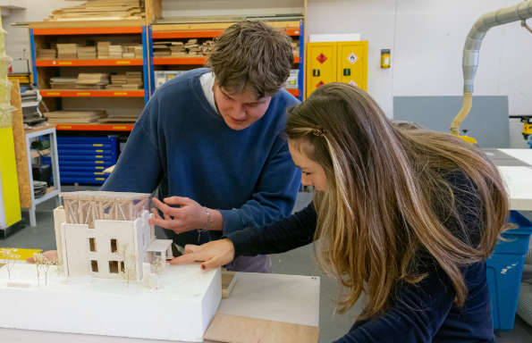 A man and a woman examining a architectural model in a model making workshop.