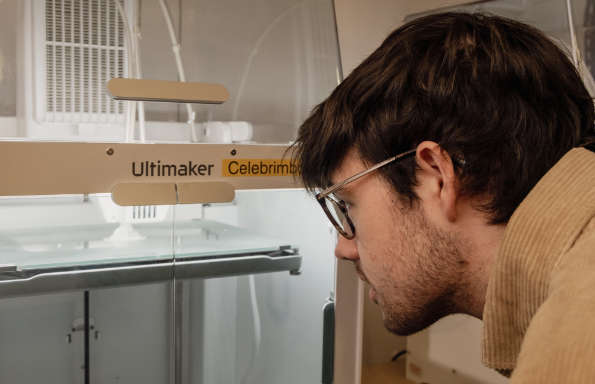 Man looking at model being printed on a 3D Printer.