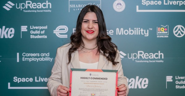 student posing with her award