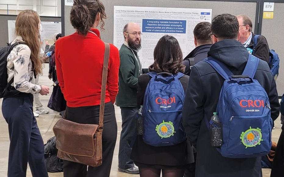 Dr Pertinez is in front of his poster animatedly talking to the attentive crowd in front of him