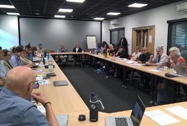 Members of the LONGEVITY consortium are sat around a circular table talking to each other