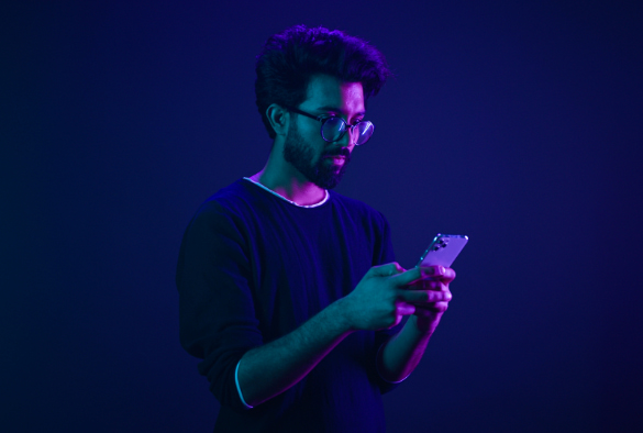 User looking at smart phone under dark neon lighting