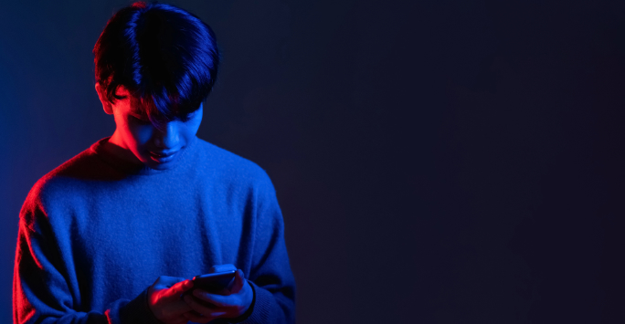 User looking at phone with dark red and blue lighting