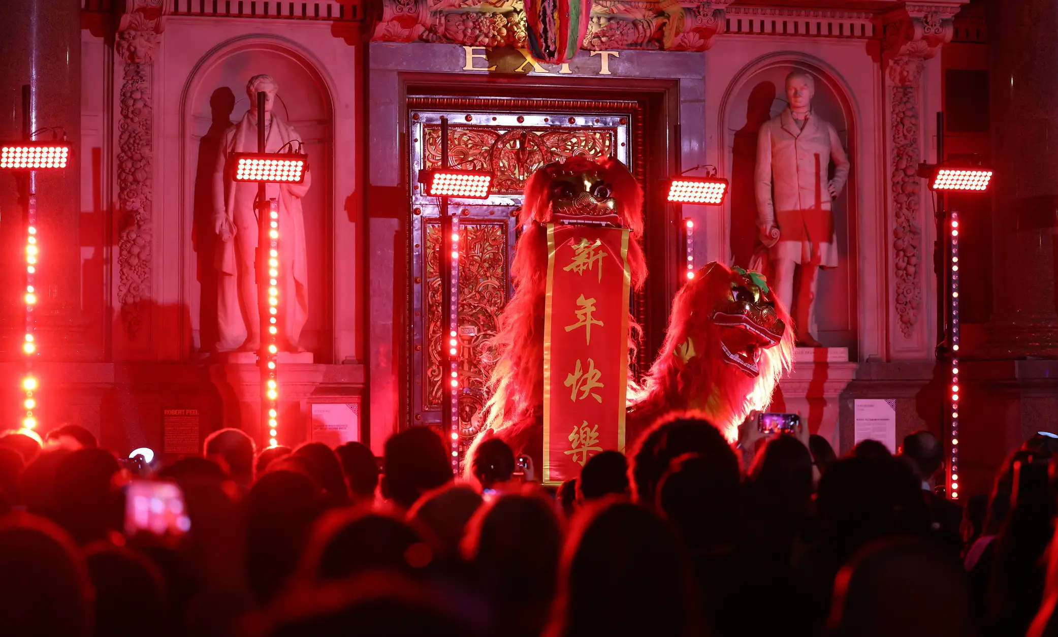 Two Chinese Lion dancers holding up a banner saying 