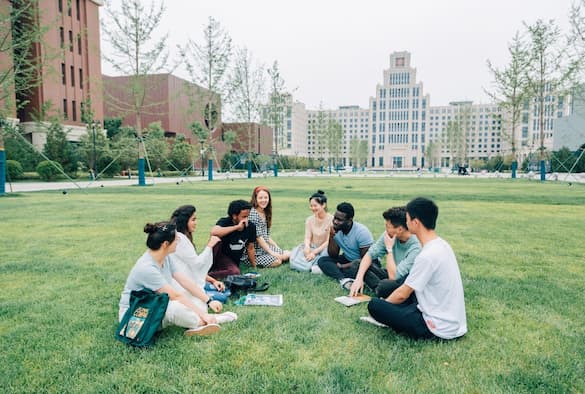 Students sitting on grass outside on the XJTU campus.