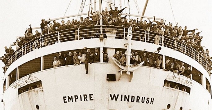 sepia image of the Empire Windrush boat with passengers waving from the decks