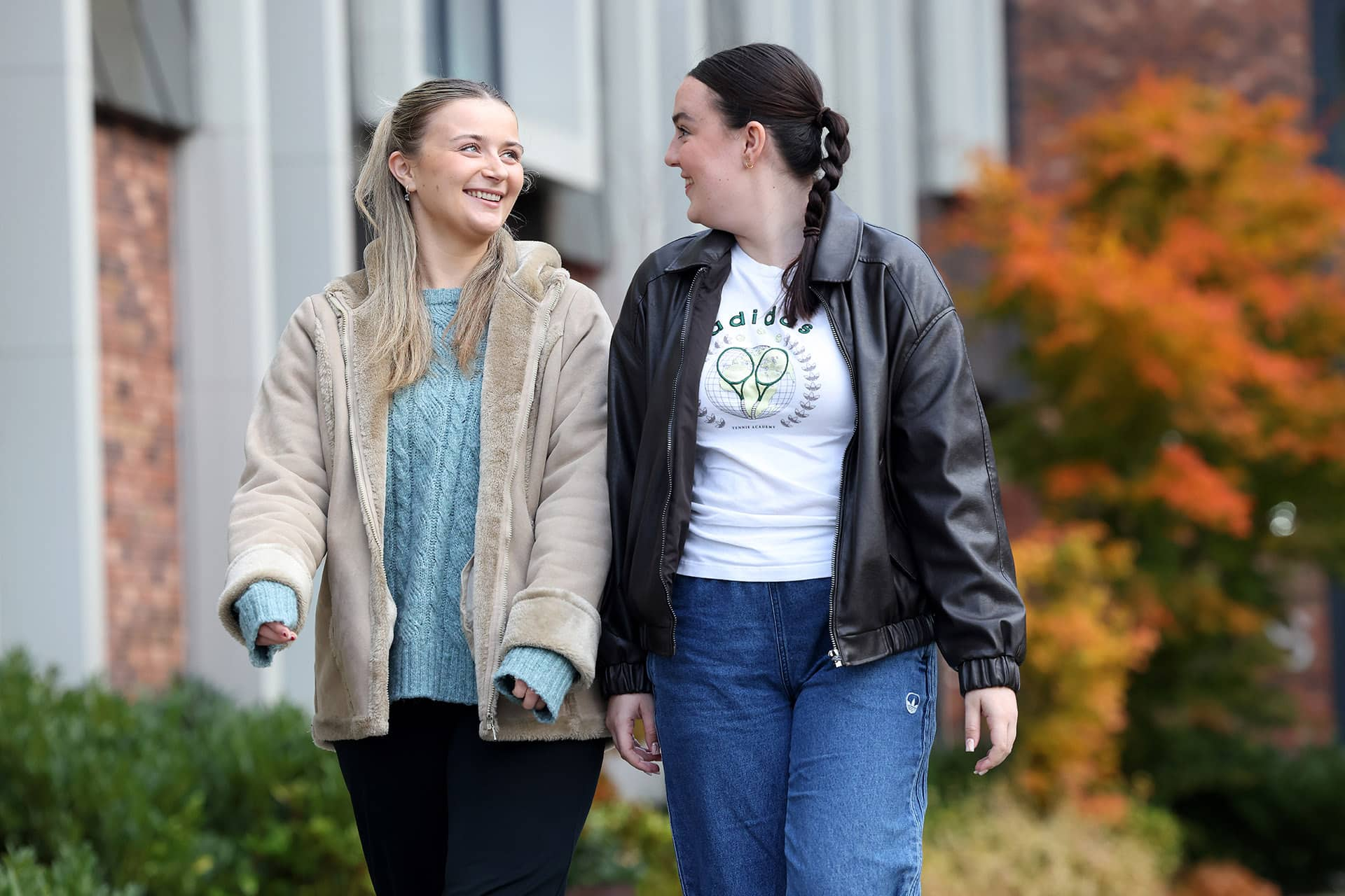 2 students chatting while walking on campus