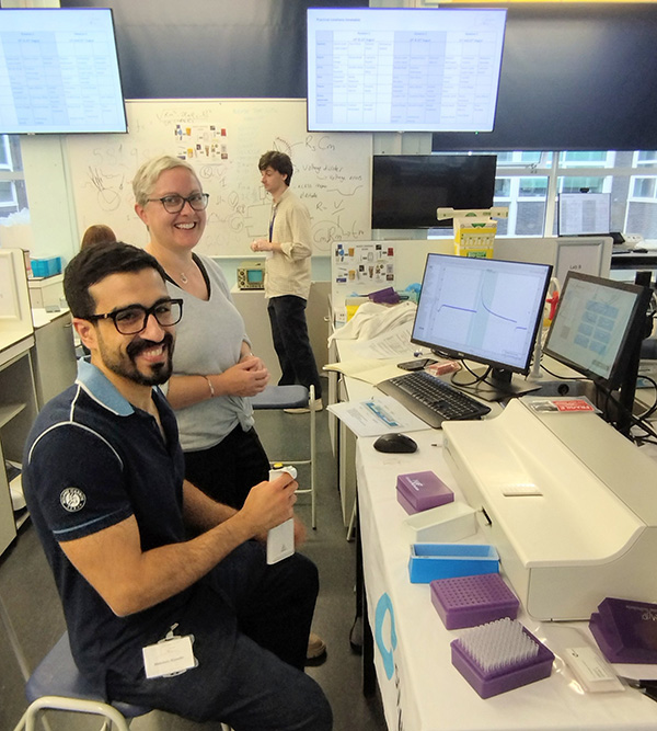 Students gathered in lab discussing at cell physiology workshop