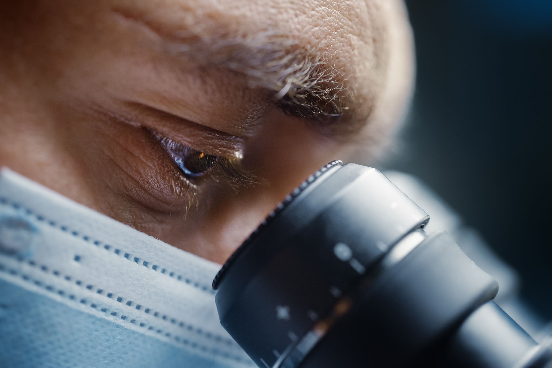 image of scientist viewing something through a microscope