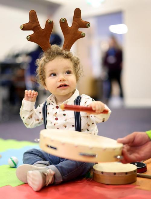 Cgull baby at Christmas party in reindeer antlers