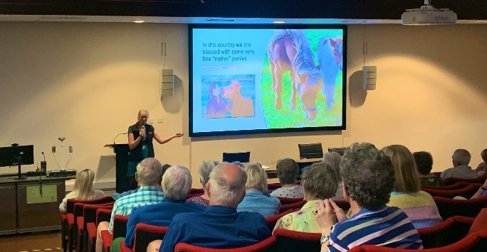 someone giving a presentation about horses to an audience