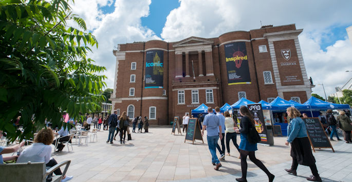 Students walking across University Square at an open day.