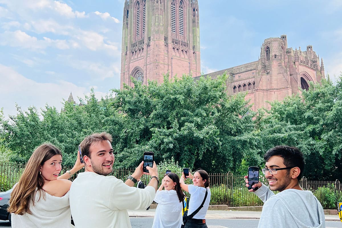 Five students gather together to take photos of a church.