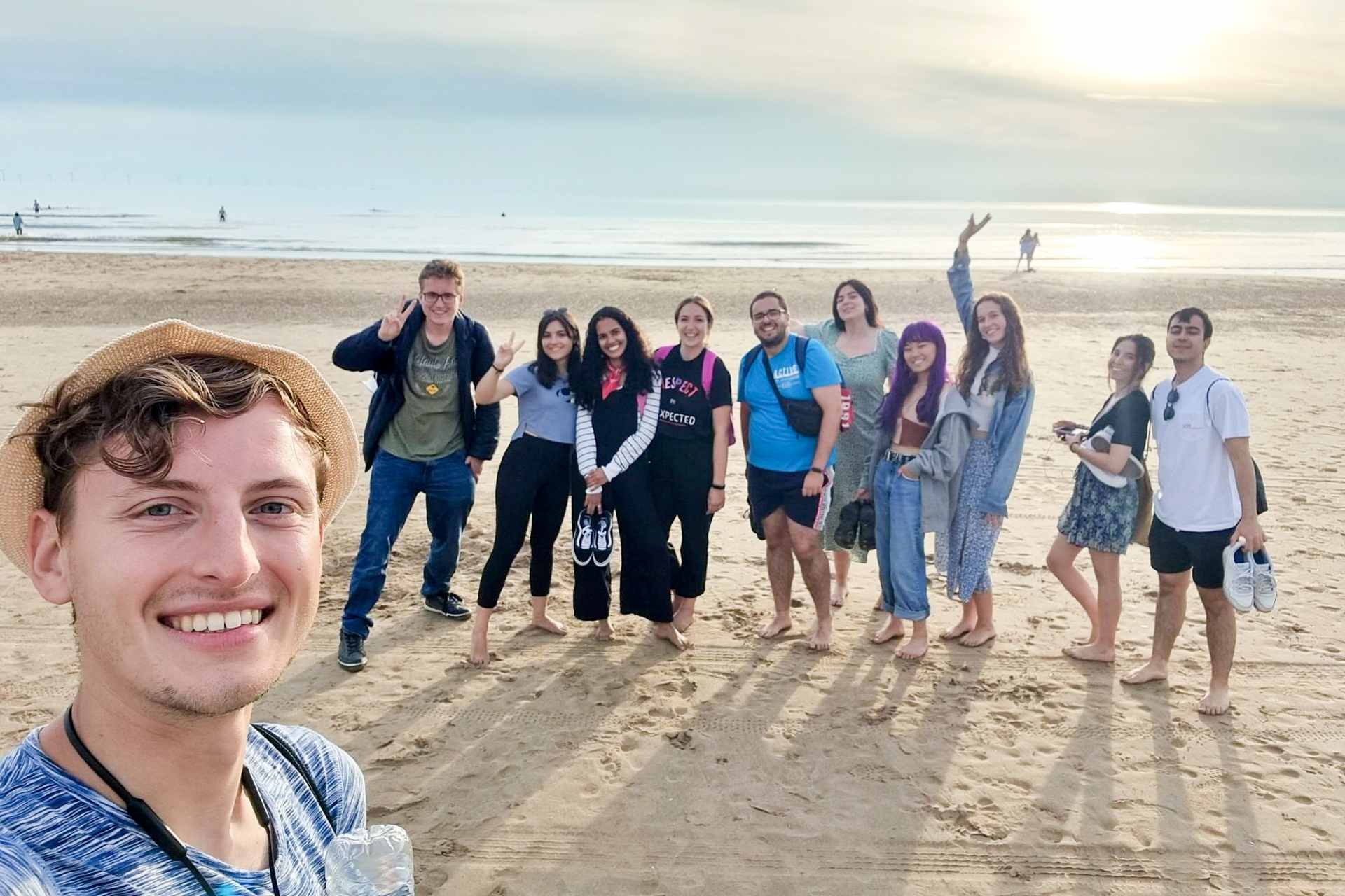 A group of international students on a beach visit in Liverpool.