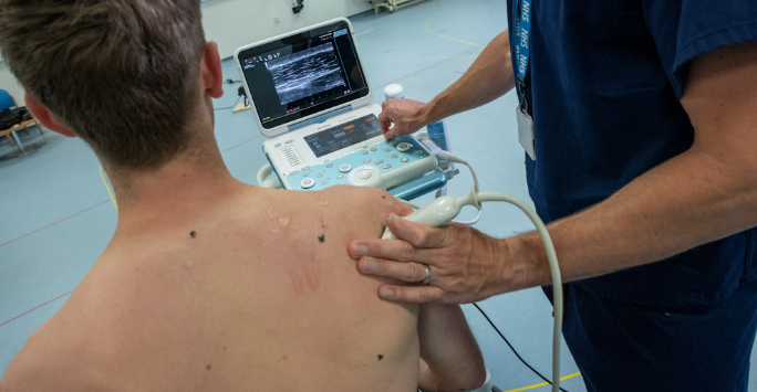 A male patient having an ultrasound to his right shoulder