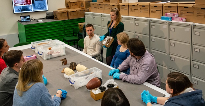 Students in object handling session in The Garstang Museum of Archaeology