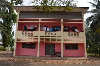 A red-fronted building with a balcony