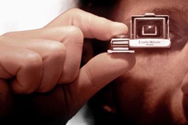 A man holding a tiny camera