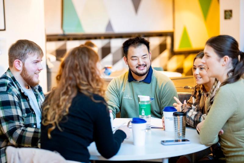 Students sat around a table talking