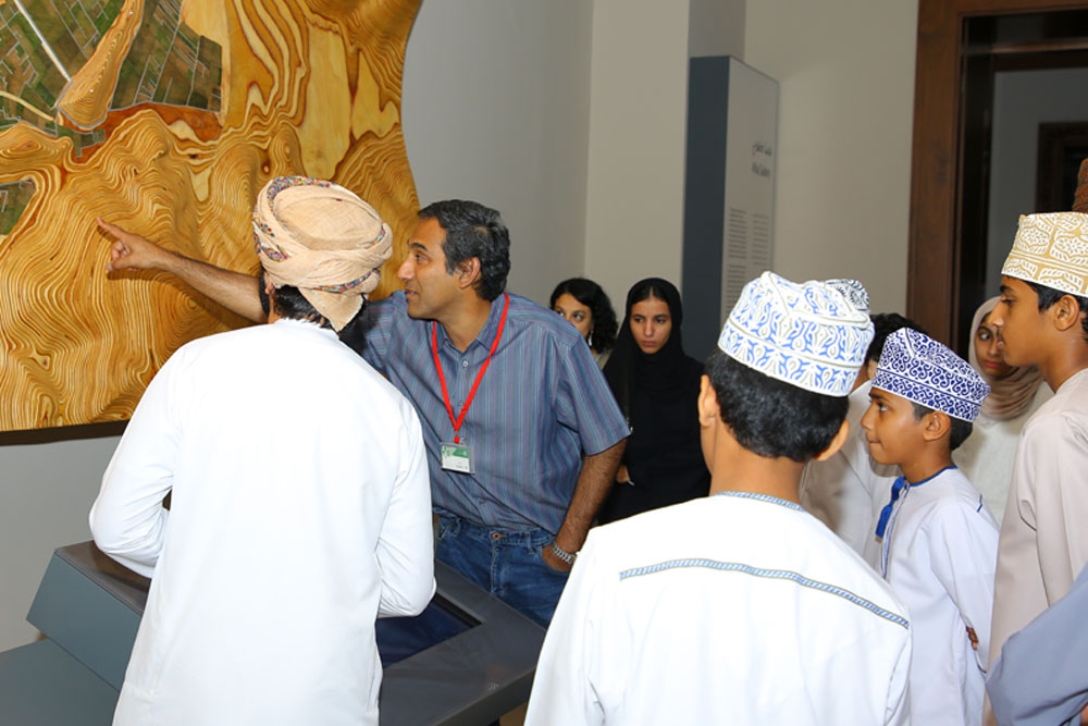 People looking at a wall-mounted architectural display