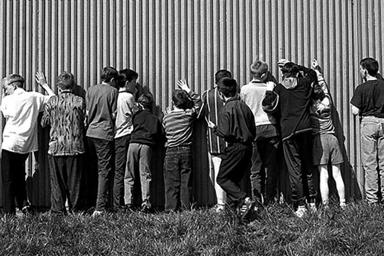 A group of boys leaning on a wall