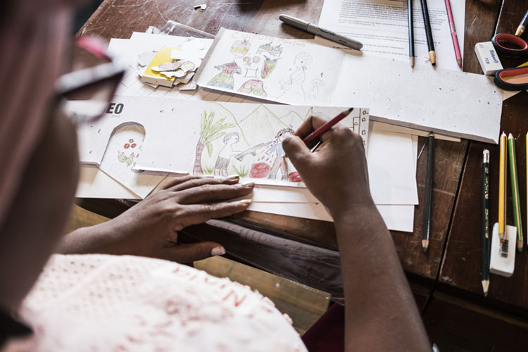 A woman, seen from above, drawing in a pad