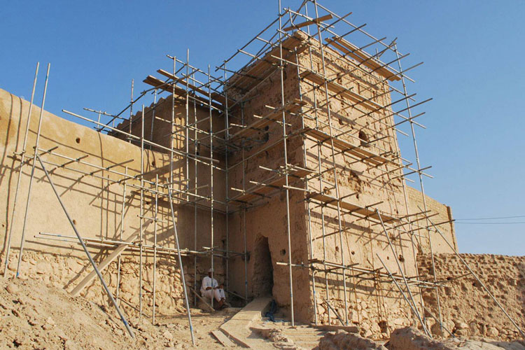 A sand-coloured building surrounded by scaffolding