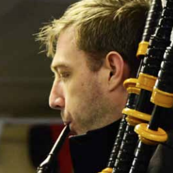 Clsoe up of a man playing pipes