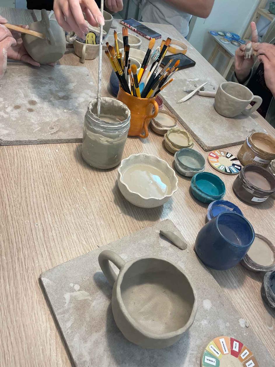 A view of clay and hands making pots and cups