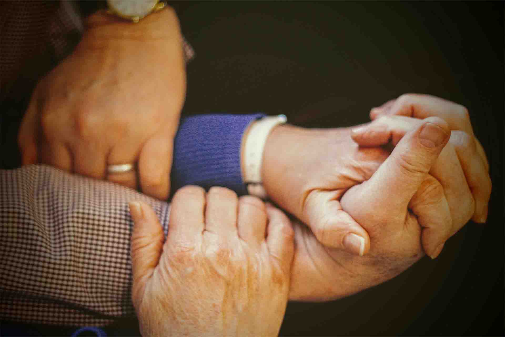 Older people holding hands.