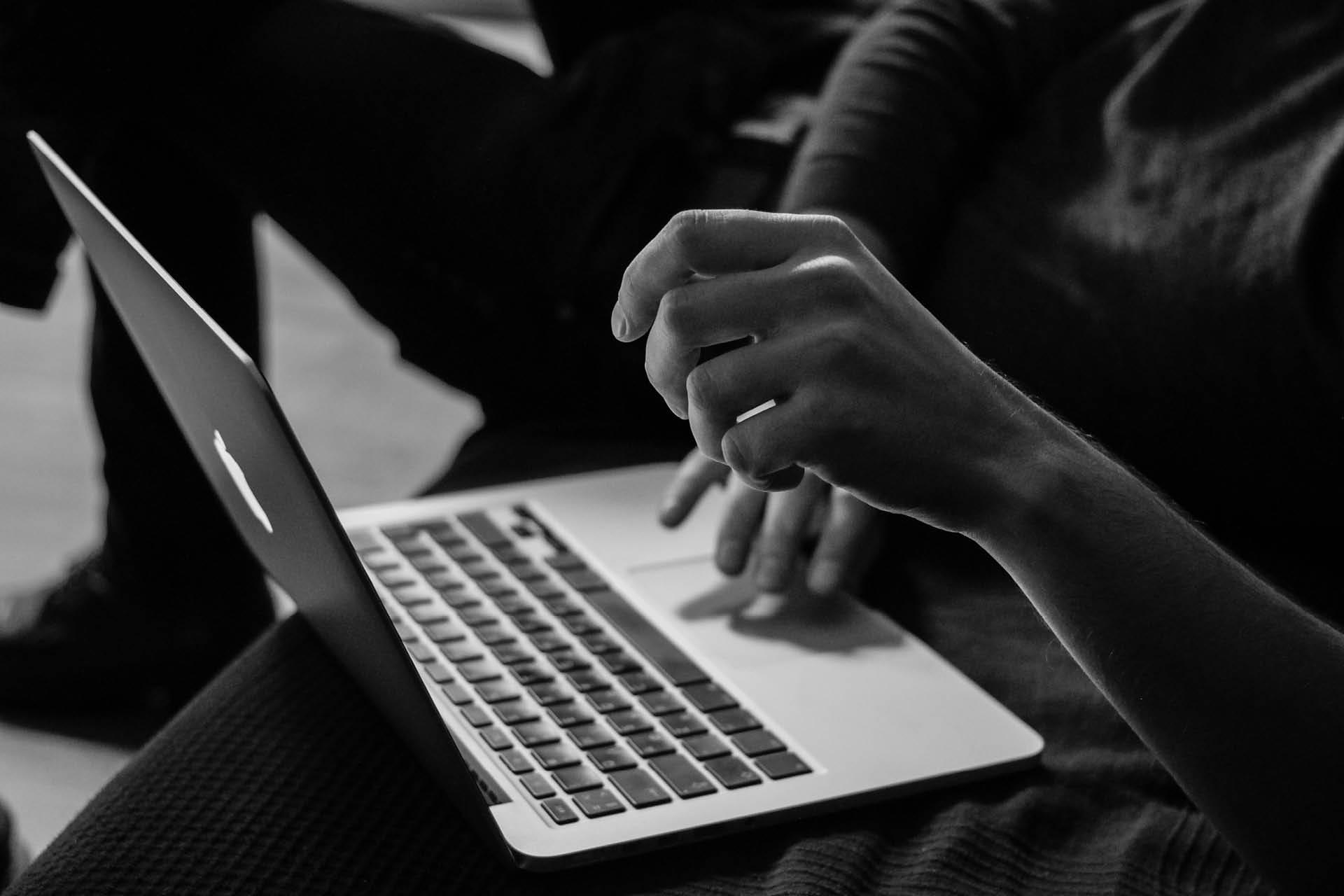 Black and white photo of someone using a computer.