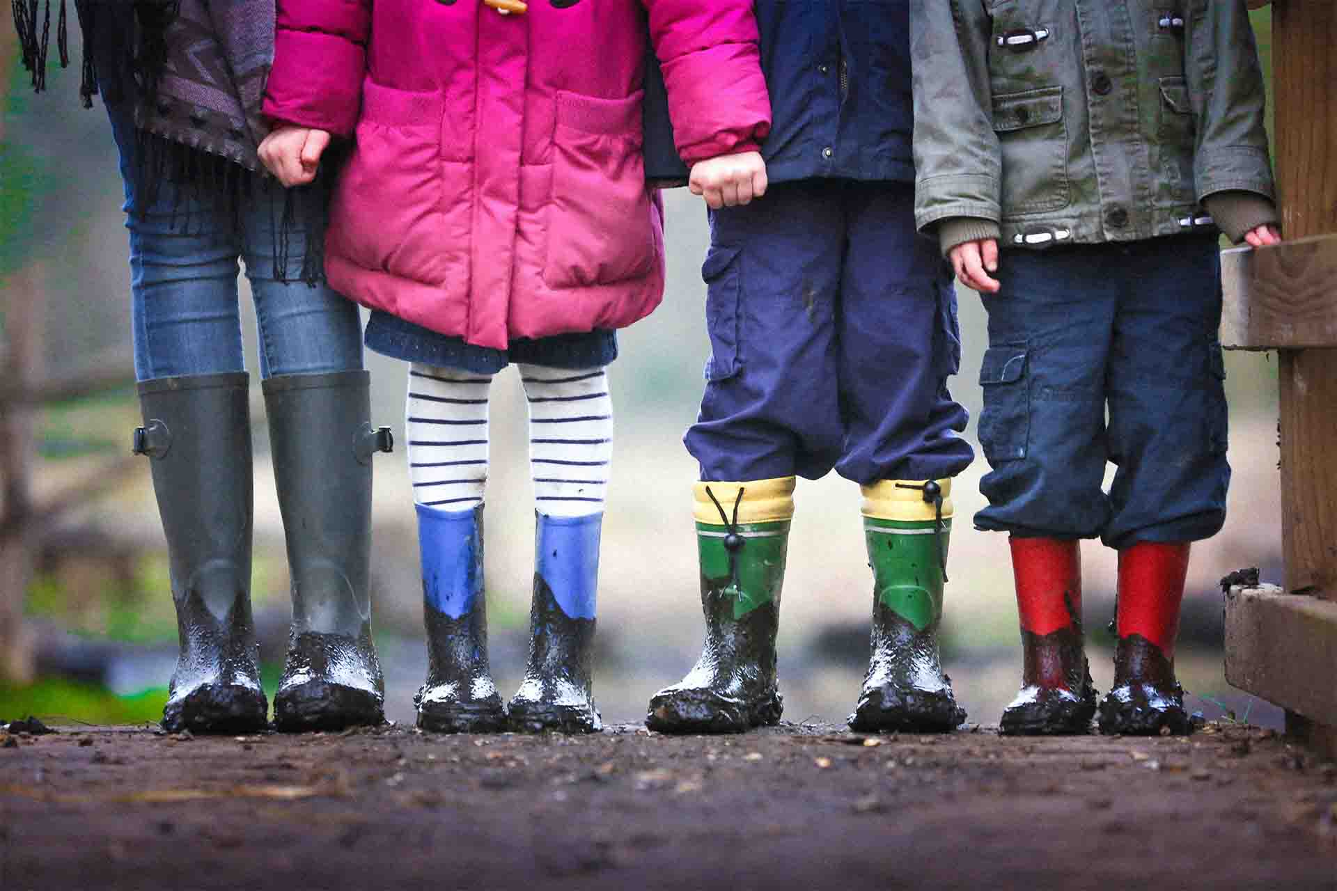 A line of children wearing wellies.